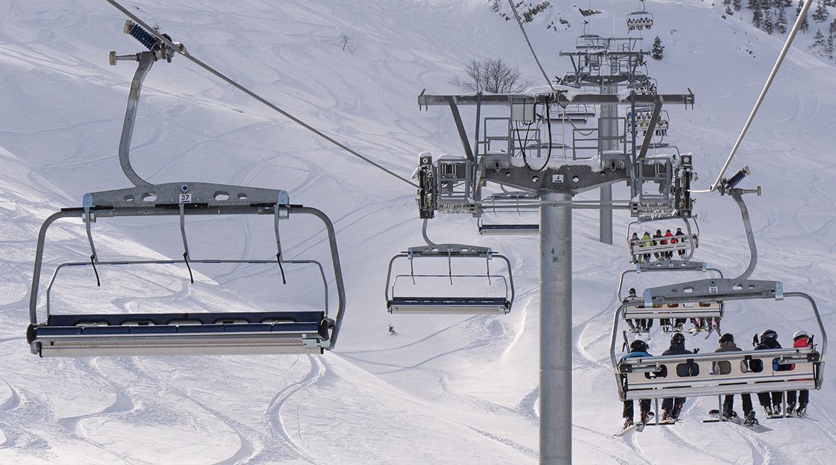 panorama of Pyrennees mountains with ski slopes and ski lift in foreground